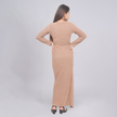 Woman wearing a beige long dress against a light gray background