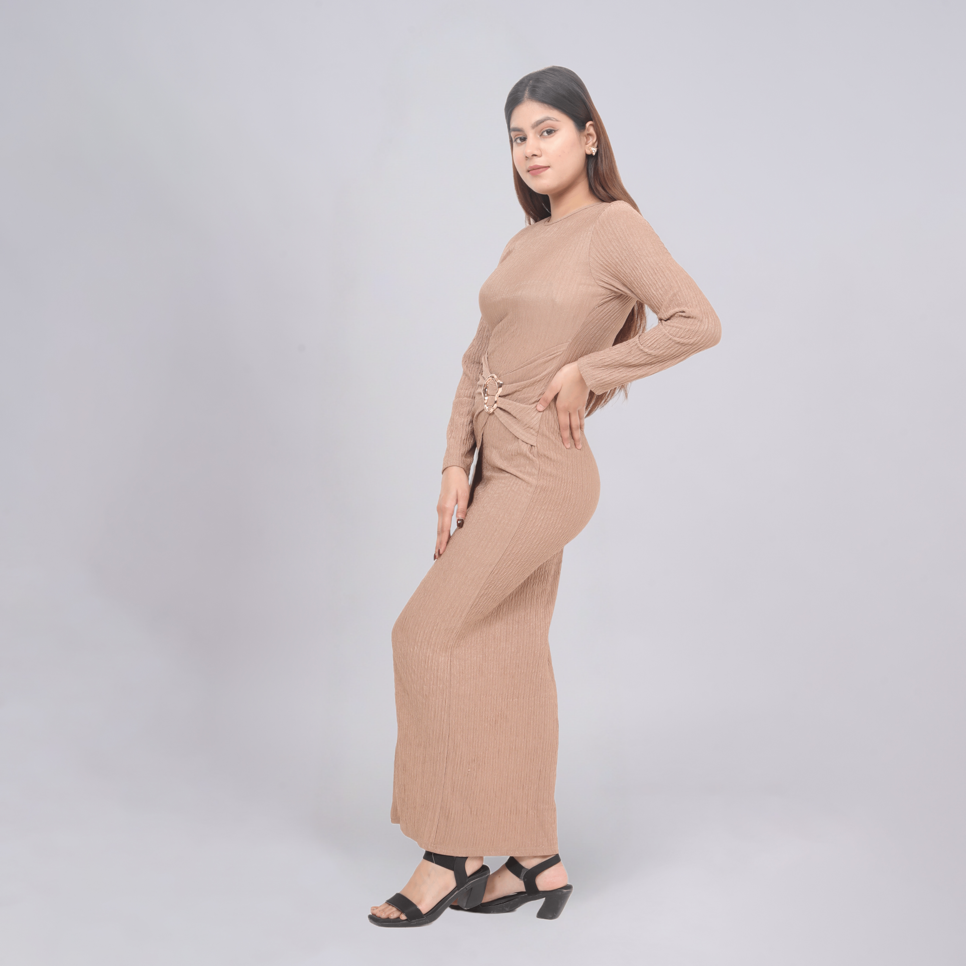 Woman wearing a beige jumpsuit on a light gray background