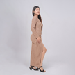 Woman wearing a beige dress with a slit on a white background