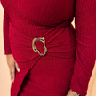 Red dress with a gold belt buckle on a beige background